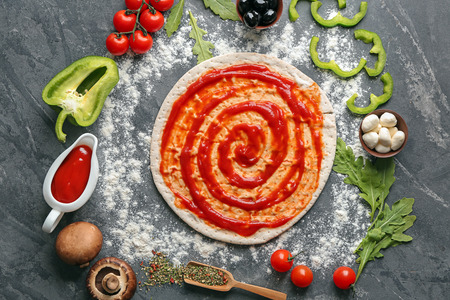 Composition with raw dough and ingredients for pizza on grey backgroundの写真素材