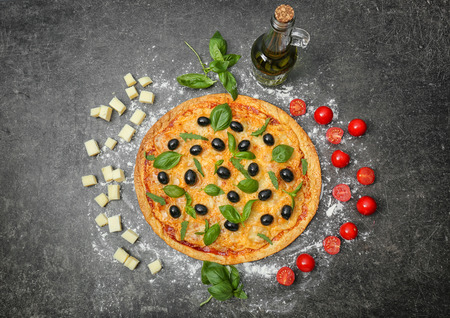 Tasty pizza with olives and ingredients on dark backgroundの写真素材