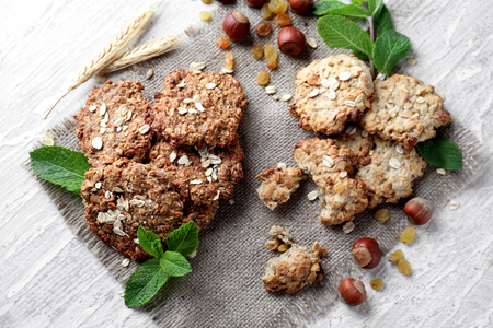 Delicious oatmeal cookies with nuts on light textured backgroundの写真素材
