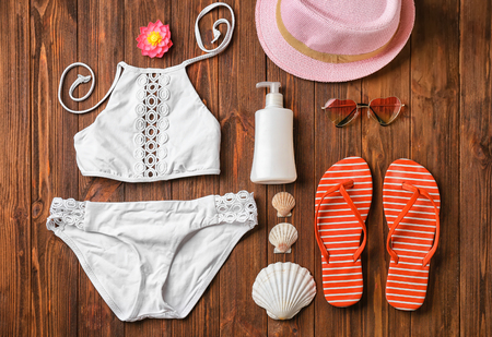 Swimming suit and beach accessories on wooden backgroundの写真素材