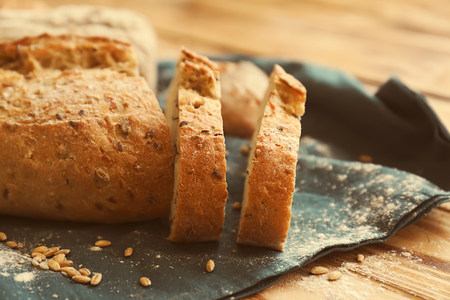 Sliced tasty bread on wooden table, closeupの写真素材