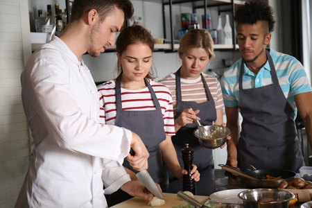 Chef and group of young people during cooking classesの写真素材