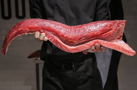 Man holding fresh tuna fillet in fish marketの写真素材