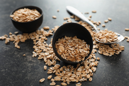Bowl with raw oatmeal on grey backgroundの写真素材