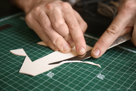 Man working with piece of leather at factory, closeupの写真素材