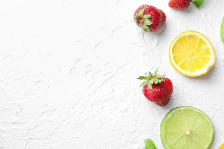 Tasty ripe strawberry with citrus fruits on light backgroundの写真素材