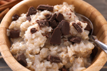 Bowl with tasty oatmeal and chocolate, closeupの写真素材