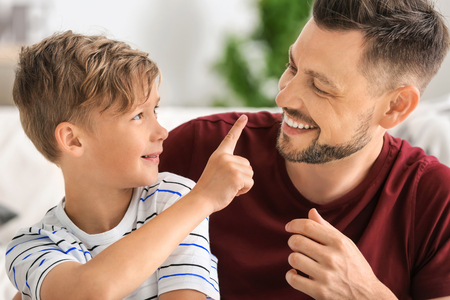 Little boy and his dad spending time together at homeの写真素材