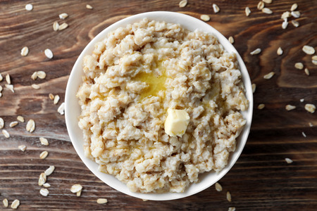Tasty oatmeal in bowl on tableの写真素材