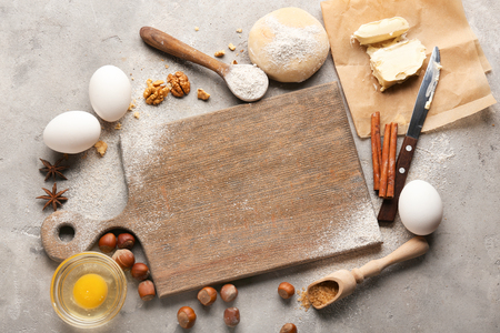 Wooden board with ingredients for preparing bakery on grey backgroundの写真素材