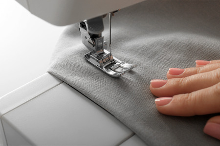 Female tailor using sewing machine, closeup