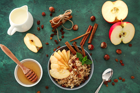 Composition with tasty oatmeal, fruit and honey on green tableの写真素材