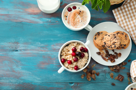 Composition with tasty oatmeal and cookies with milk on wooden backgroundの写真素材