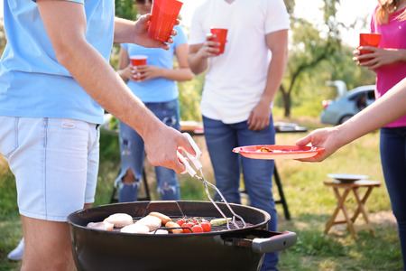 Young people having barbecue party in parkの写真素材