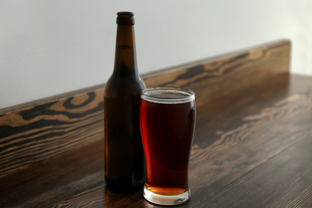 Glass and bottle of cold beer on wooden tableの写真素材