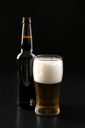Glass and bottle of cold beer on dark backgroundの写真素材