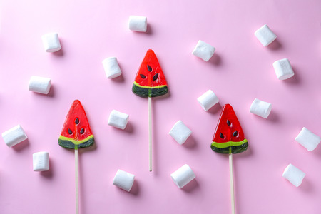 Delicious lollipops with marshmallows on color backgroundの写真素材