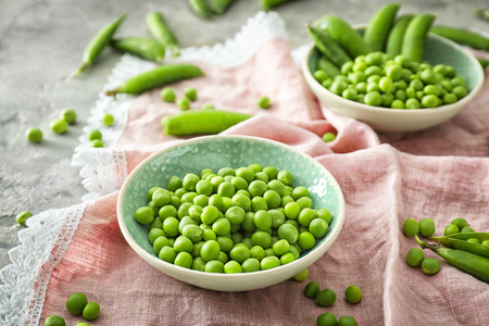 Bowl with fresh green peas on tableの写真素材