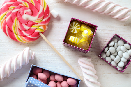 Composition with colorful candies and marshmallows on light wooden backgroundの写真素材