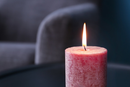 Burning wax candle on blurred backgroundの写真素材