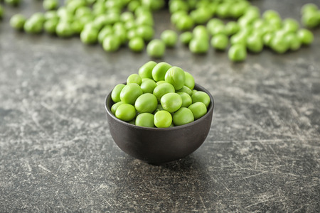 Bowl with green peas on grey backgroundの写真素材