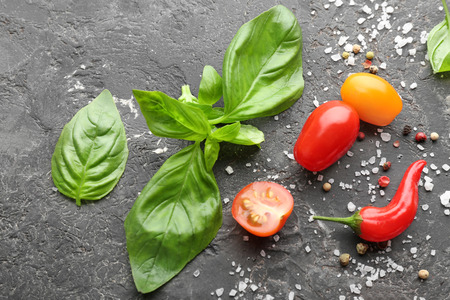 Fresh basil with spices and vegetables on grey backgroundの写真素材