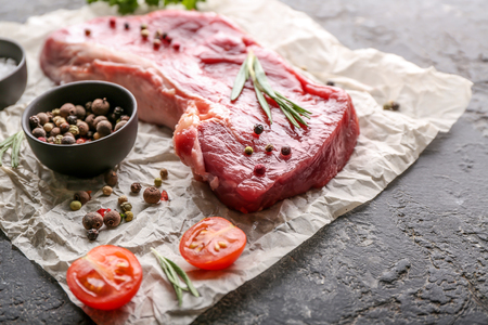 Piece of raw meat and spices on grunge backgroundの写真素材