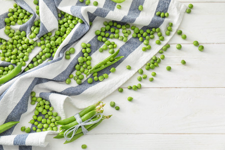 Delicious fresh green peas on white wooden backgroundの写真素材