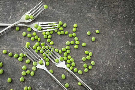 Fresh green peas and forks on grey backgroundの写真素材