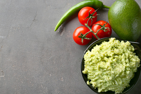 Tasty guacamole with ingredients on grey textured backgroundの写真素材