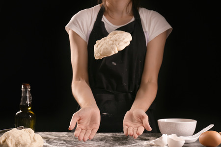 Woman kneading dough for bakery on kitchen tableの写真素材