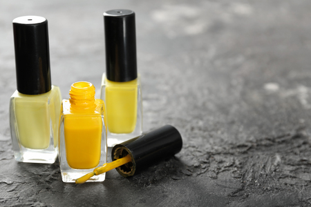 Bottles of yellow nail polish on grunge tableの写真素材