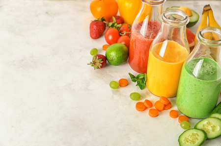 Bottles with fresh tasty smoothies and ingredients on tableの写真素材