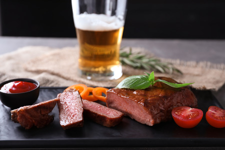 Plate with tasty grilled steak on tableの写真素材