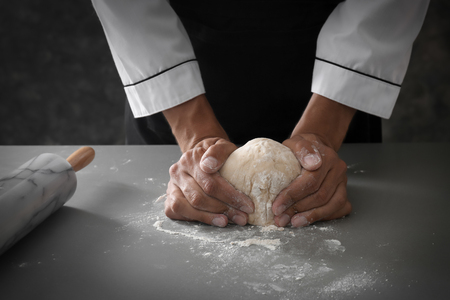 Man kneading dough in kitchen