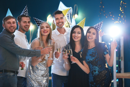 Young people with glasses of champagne at birthday party in clubの写真素材