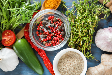 Various spices with herbs and vegetables on wooden backgroundの写真素材
