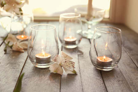 Beautiful burning candles in glasses on wooden windowsillの写真素材