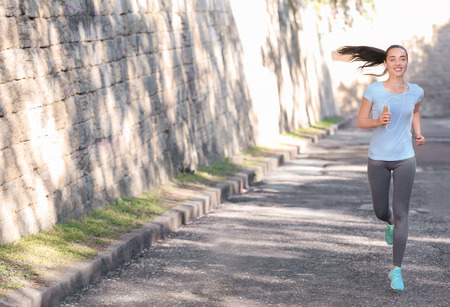 Sporty young woman running outdoorsの写真素材
