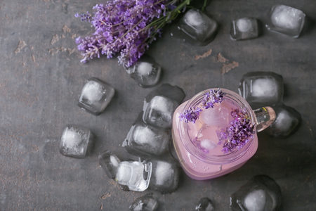 Mason jar with lavender lemonade and ice cubes on grey backgroundの写真素材