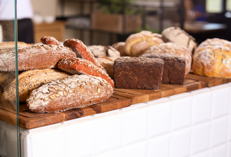 Assortment of fresh bread on counter in bakeryの写真素材