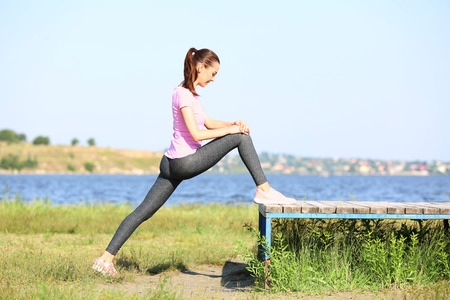 Beautiful young woman training in park