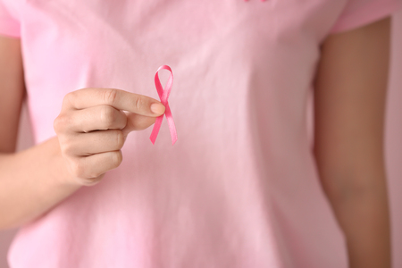 Beautiful woman holding pink ribbon, closeup. Breast cancer conceptの写真素材