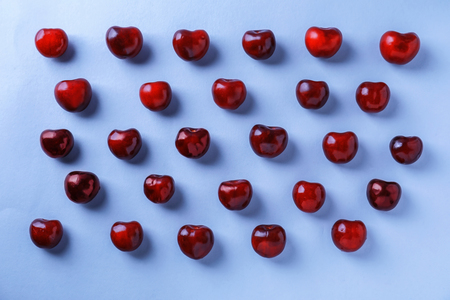Flat lay composition with ripe cherries on color backgroundの写真素材
