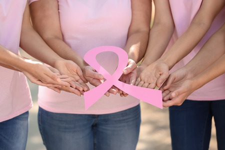 Women of different ages holding pink ribbon outdoors. Breast cancer conceptの写真素材