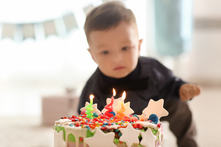 Cute little boy with birthday cake at home