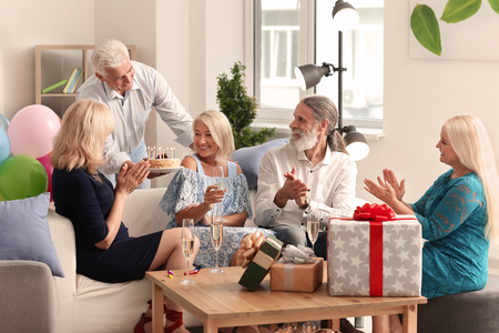 Mature people at birthday party at homeの写真素材