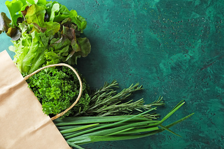 Paper bag with fresh herbs on color backgroundの写真素材