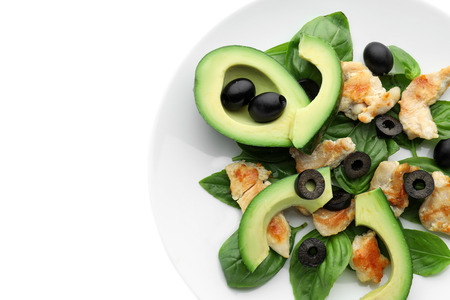 Salad with ripe avocado on plate against white backgroundの写真素材