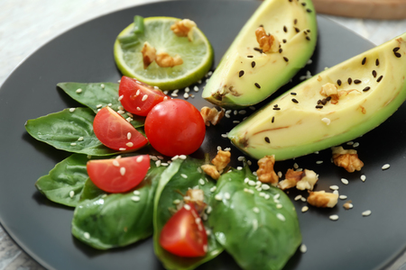Ripe avocado, tomatoes and herbs on plate, closeupの写真素材